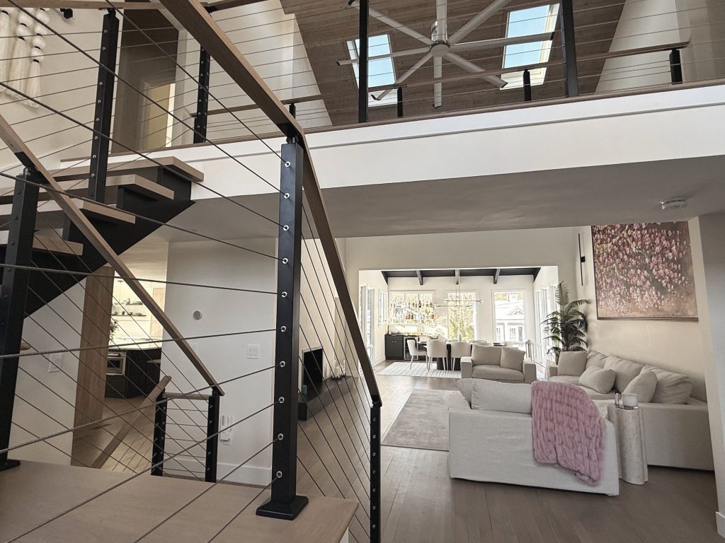 Open riser stair beside a double height living room